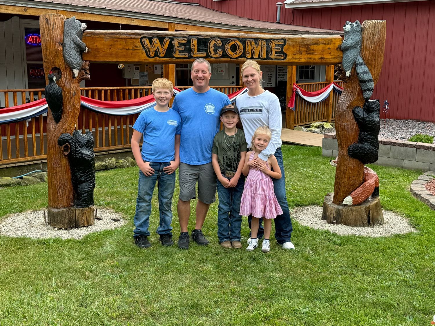 The Rasmussen family under the hand-carved welcome arch outside the campground office