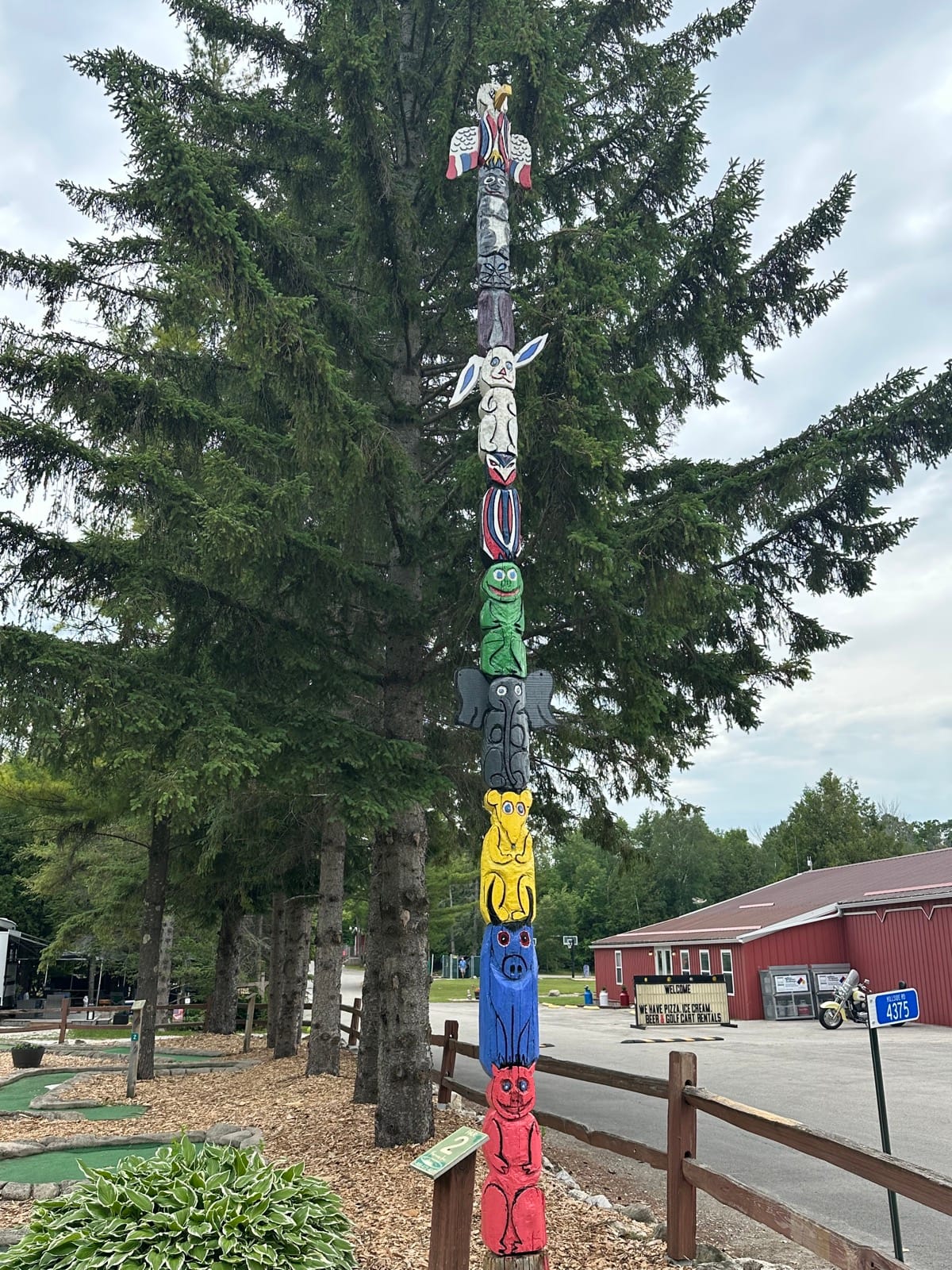 The totem pole beside the mini golf course, with the office building behind it